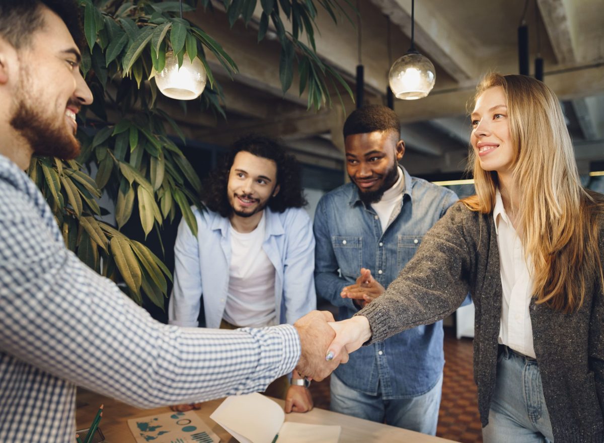 female office executive shaking hand new male team member employee (1)